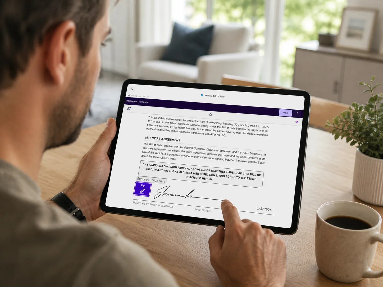 Buyer signing the vehicle bill of sale digitally on a tablet